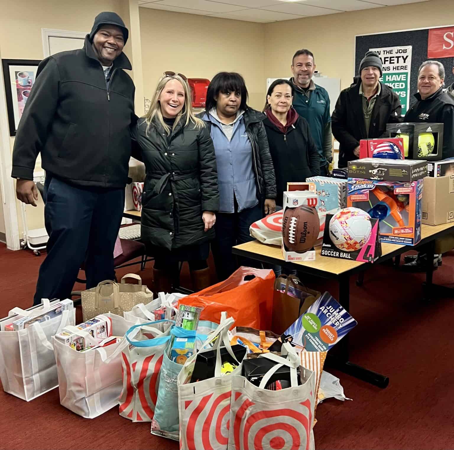 Union members gather for charity event with gift bags and toys.