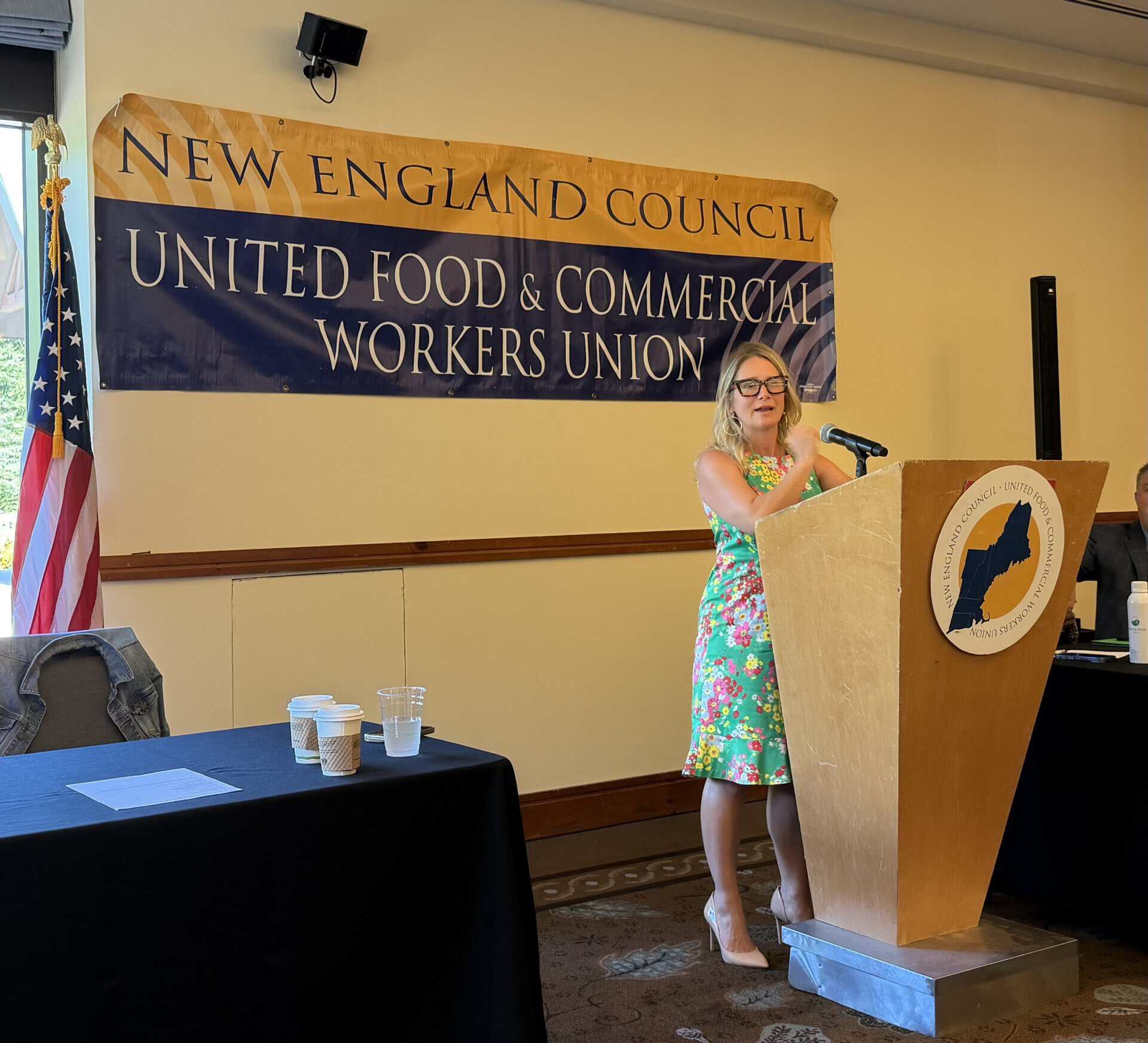 Woman speaking at a podium during a United Food & Commercial Workers Union event in New England.