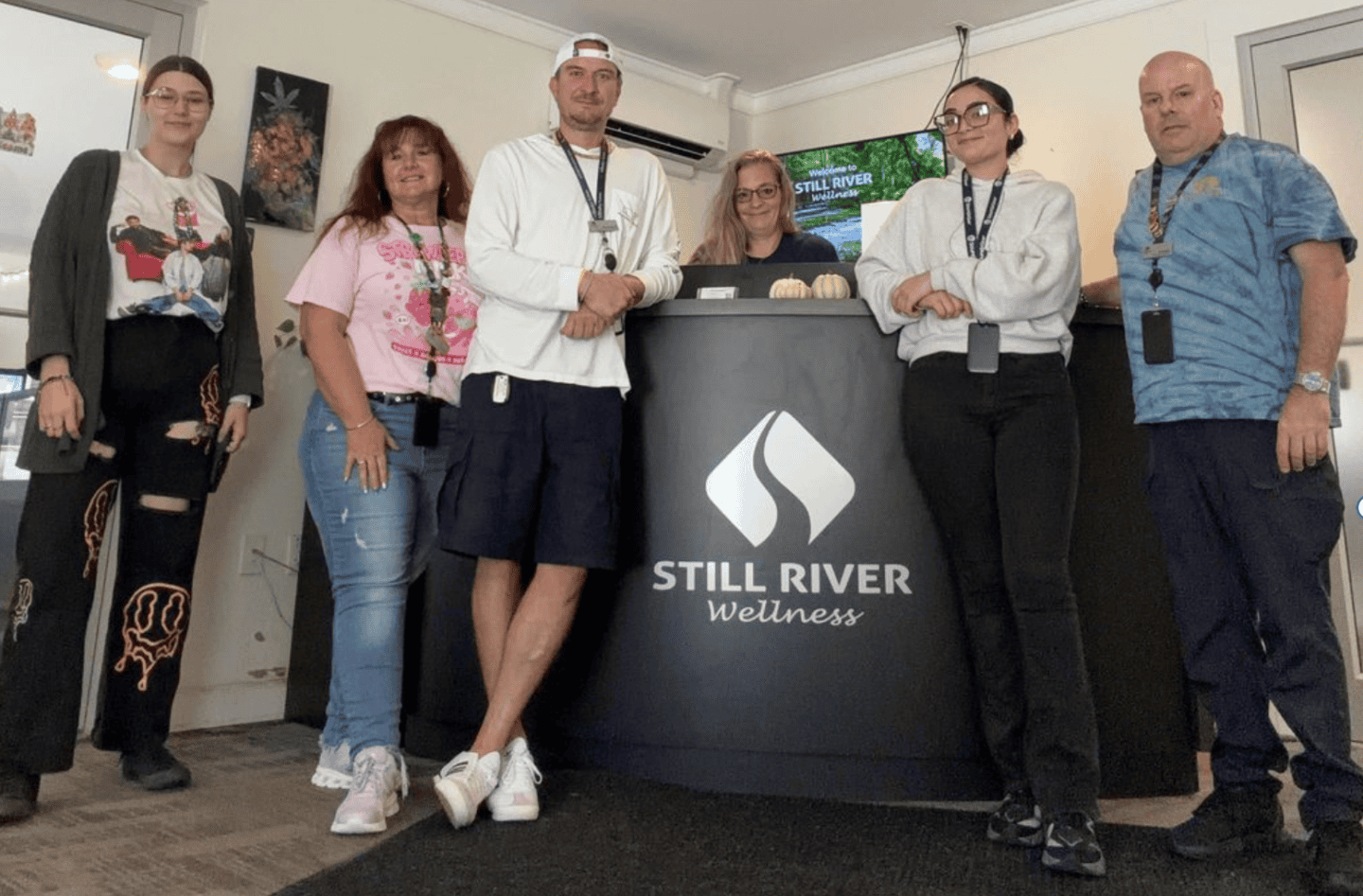 Group of people at Still River Wellness reception desk in a wellness center.
