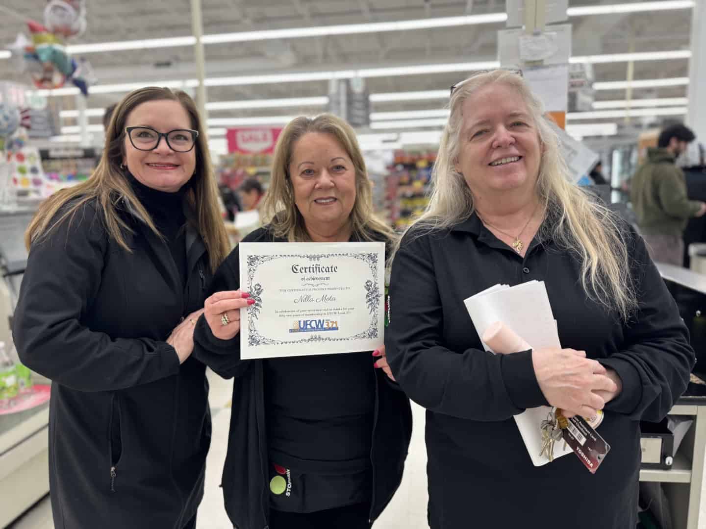 Three Stop & Shop workers holding a UFCW Local 371 certificate.