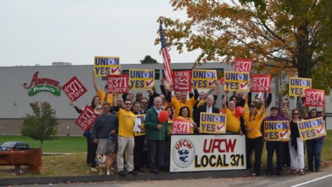 Aurora Products workers holding UFCW Local 371 signs outside their workplace.