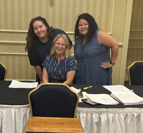 Three Complete Care workers at a union meeting.