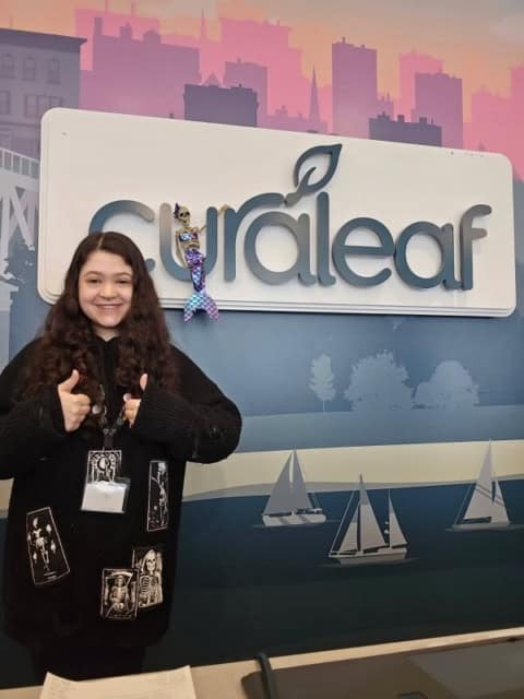 Nicole giving a thumbs-up beside the Curaleaf sign.