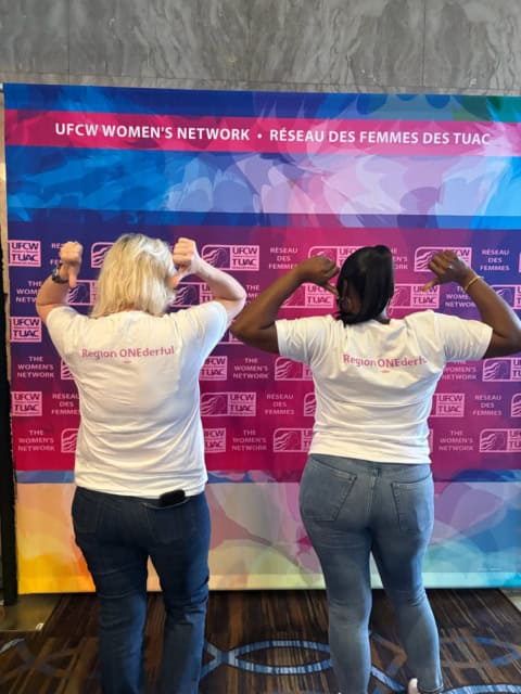 Two women flexing muscles at UFCW Women's Network event.